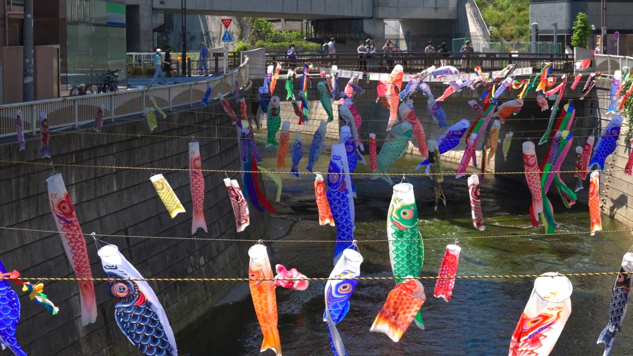 在日本东京新宿高田桥的儿童节，小inobori鲤鱼飘带在风中飘过神田河视频素材