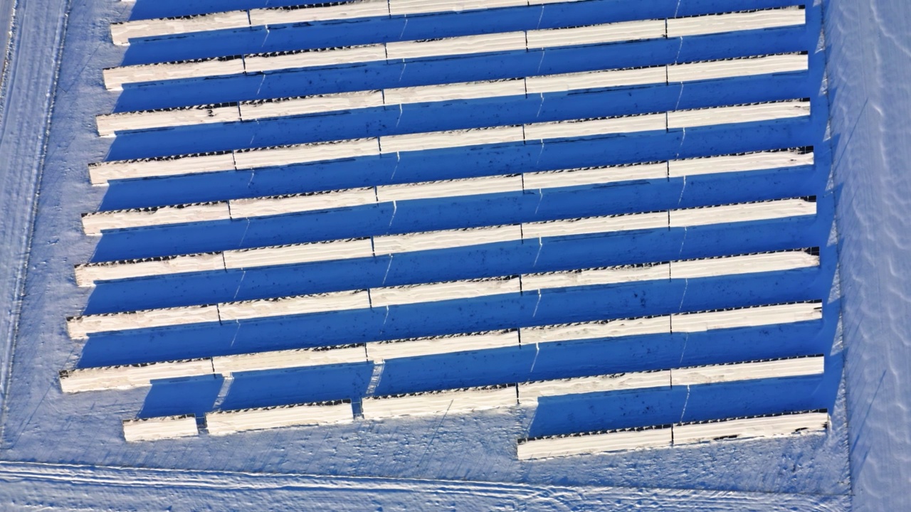 阳光明媚的冬天，多雪的太阳能电池板。波兰鸟瞰图视频下载
