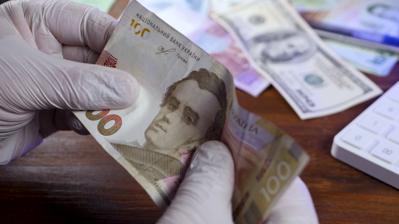 戴着橡胶手套的会计的手检查现金乌克兰货币是否虚假视频下载