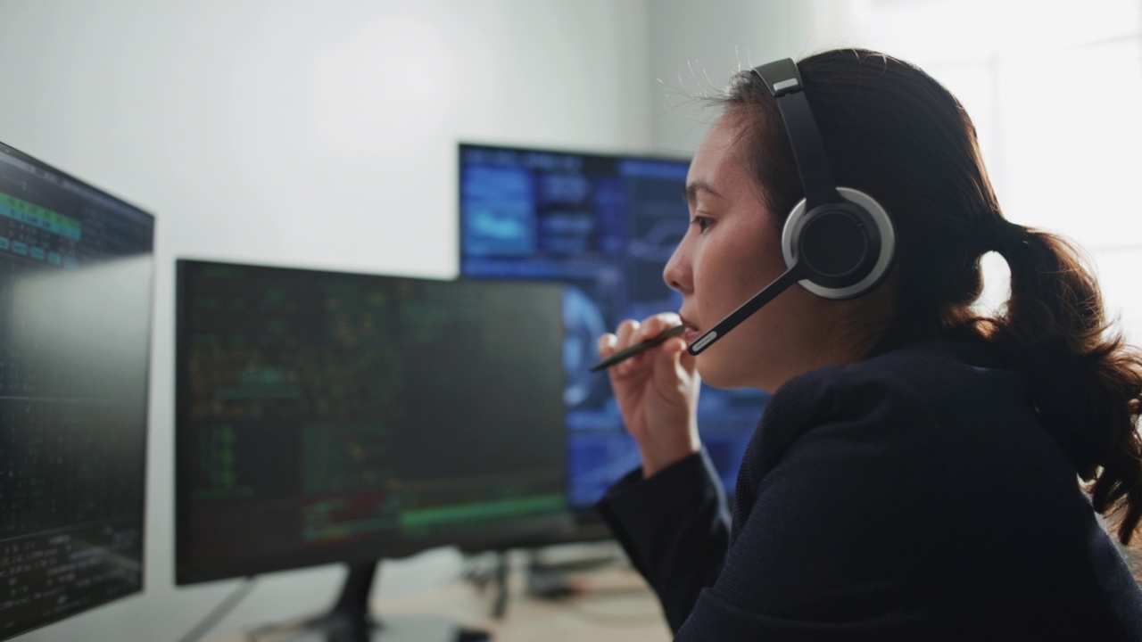 呼叫中心的工作人员在办公室的电脑上戴着耳机讲话视频素材
