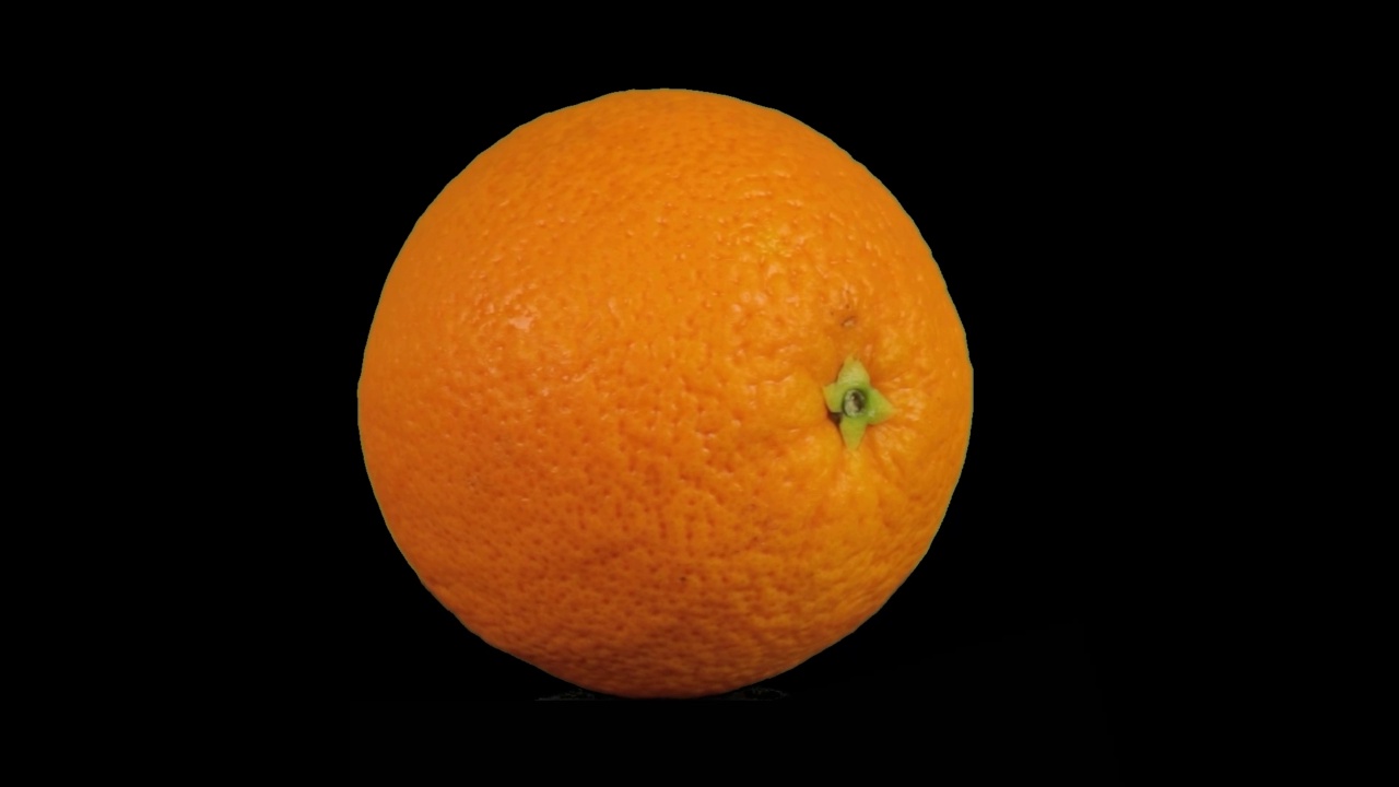 橙色的果实孤立在黑色上，橙色的旋转围绕着自己视频素材