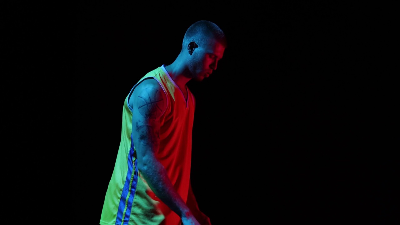 职业篮球运动员在黑暗的背景下在篮筐里投球。运动，动作，动作，技能概念视频素材