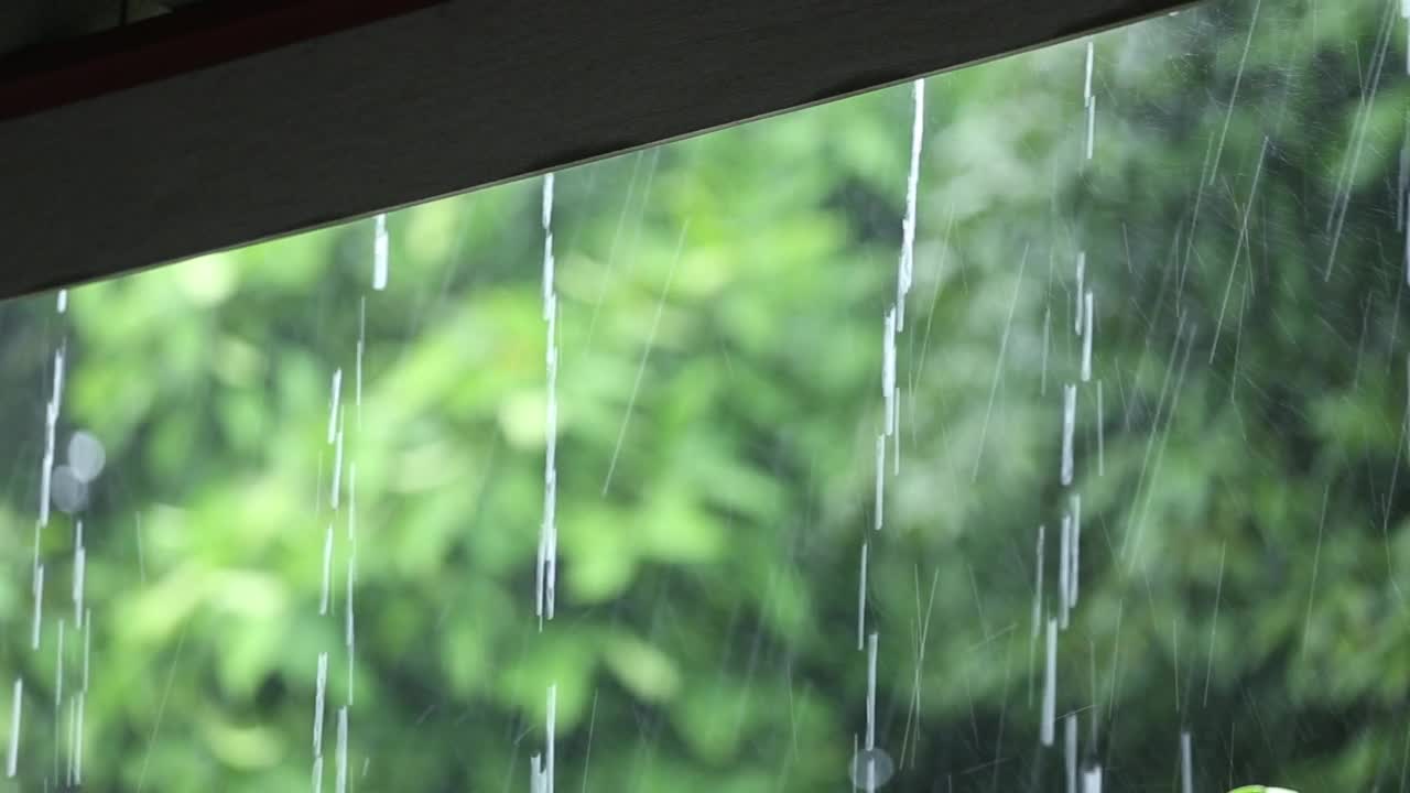 天在下雨，雨水从屋顶上倾泻而下。视频下载