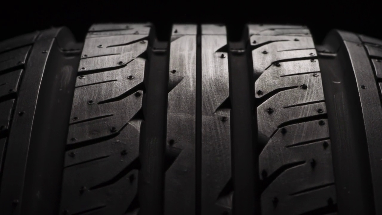 汽车轮胎旋转在黑色背景视频下载