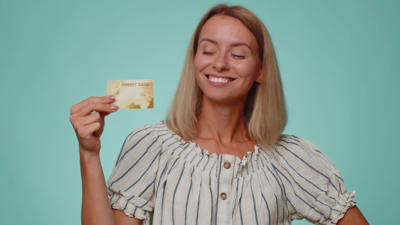 快乐的女子展示塑料信用卡的广告无现金转账，网上购物视频素材
