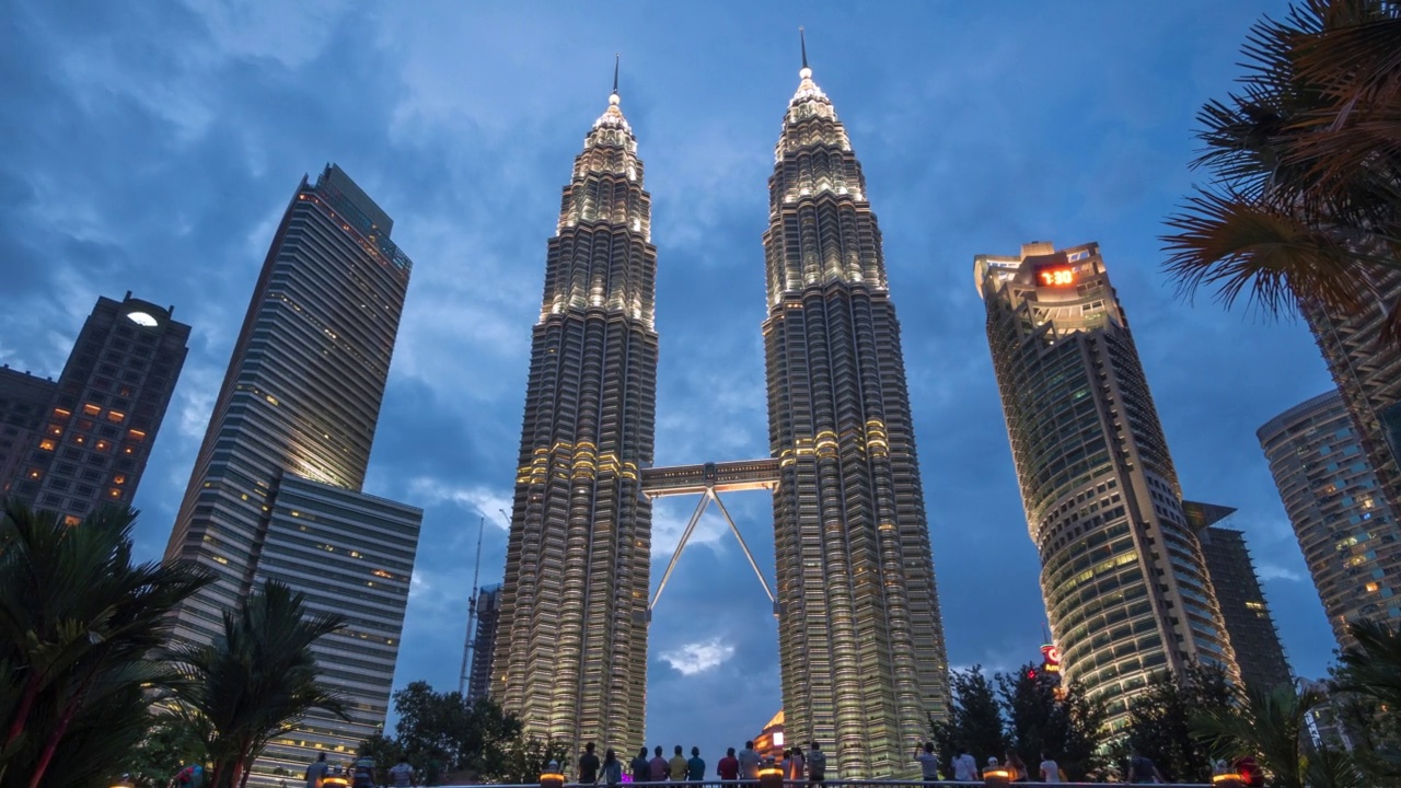 从黄昏到夜晚，马来西亚吉隆坡的建筑地标双子塔的时间推移视图，缩小视频下载