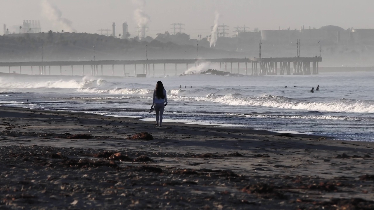 清晨，一个女人走在海滩上视频下载