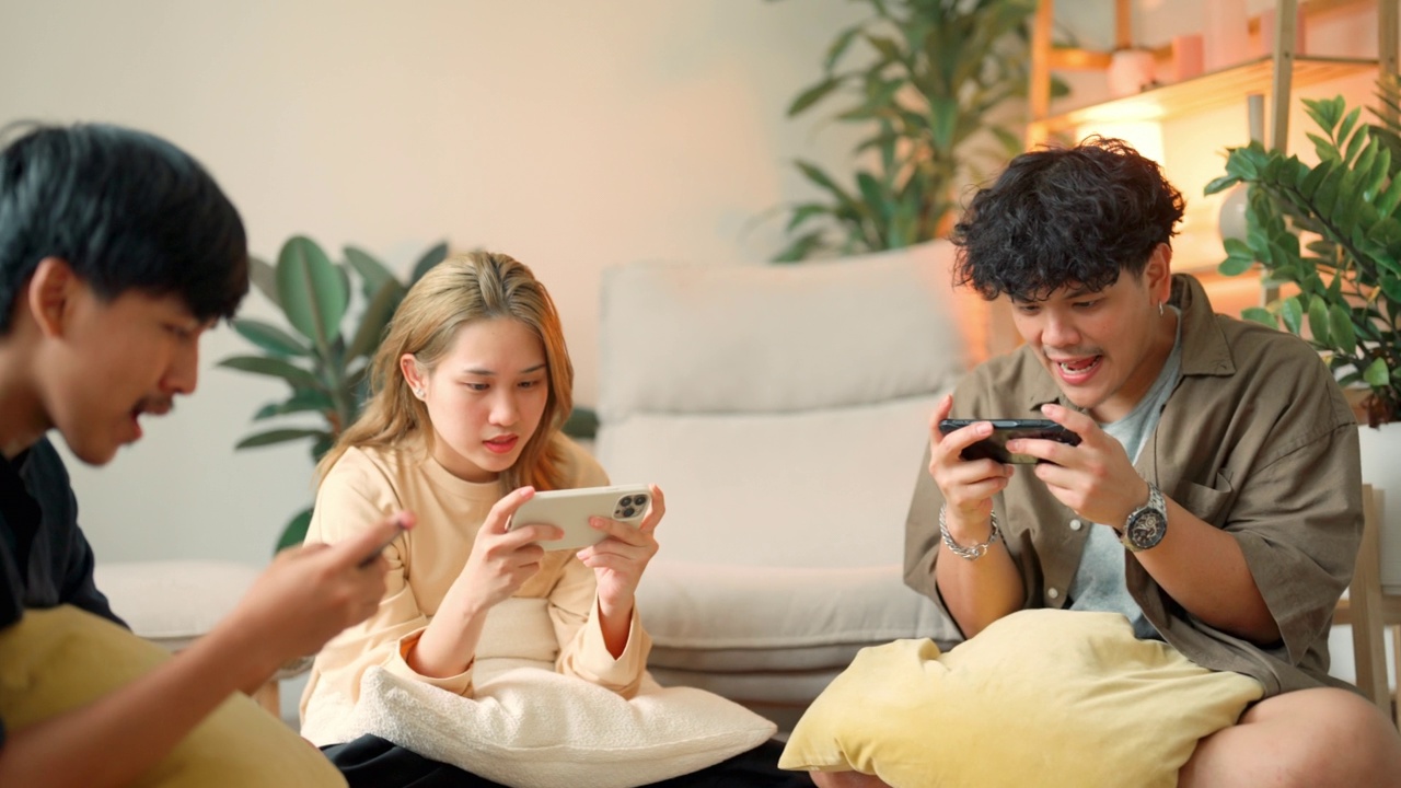 亚洲青少年在客厅用手机玩手机游戏。视频素材