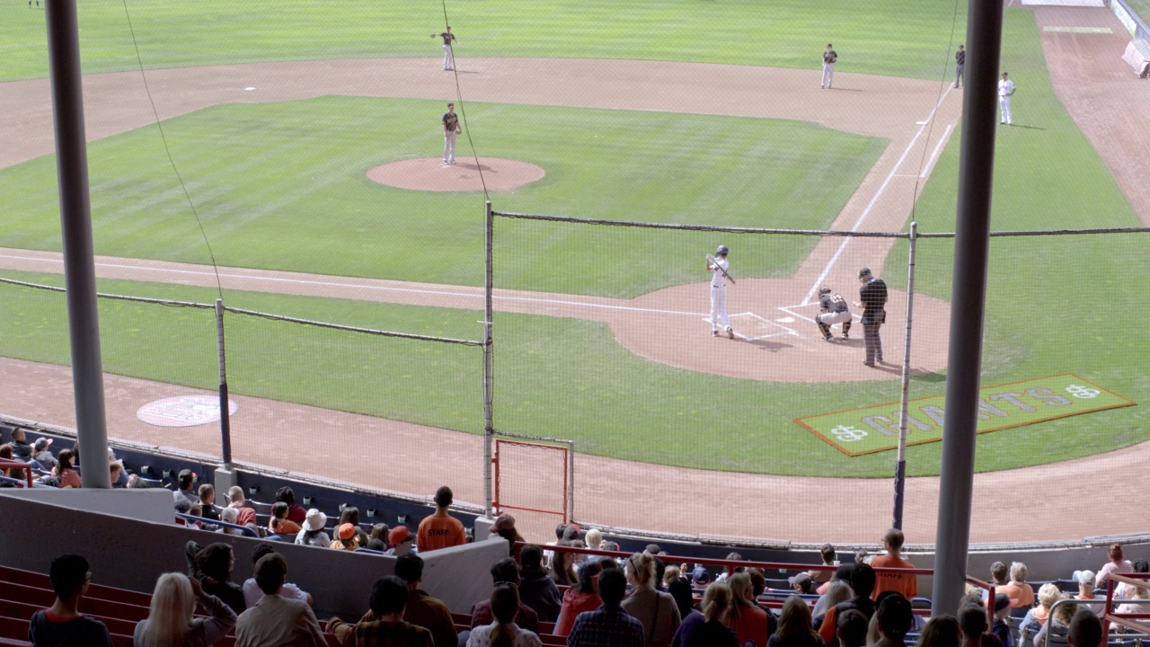 中等角度的棒球队在兴奋的棒球场比赛。可能是小联盟的圣荷西巨人队。看台或看台上的观众视频下载