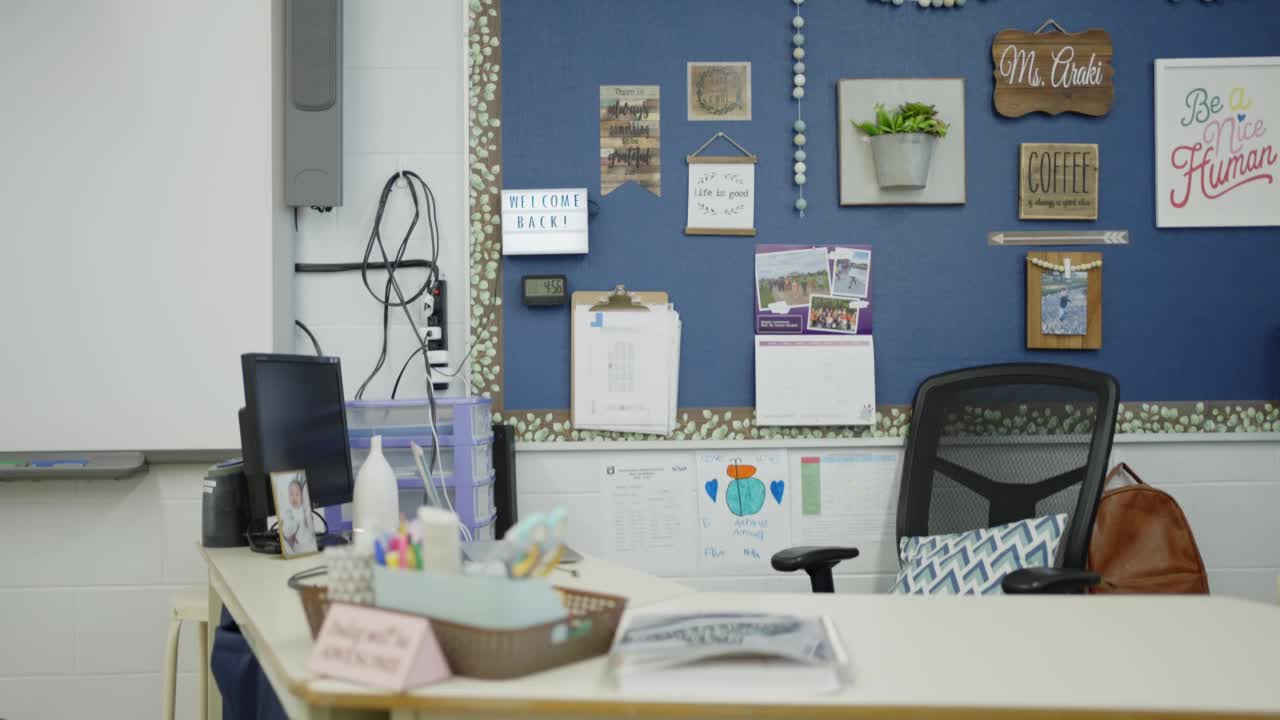 教室前面的教师办公桌，旁边排列着桌椅视频素材