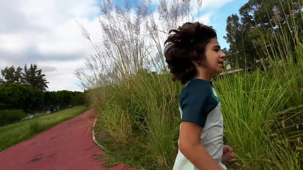 一个男孩在公园慢跑的4K慢动作视频视频素材