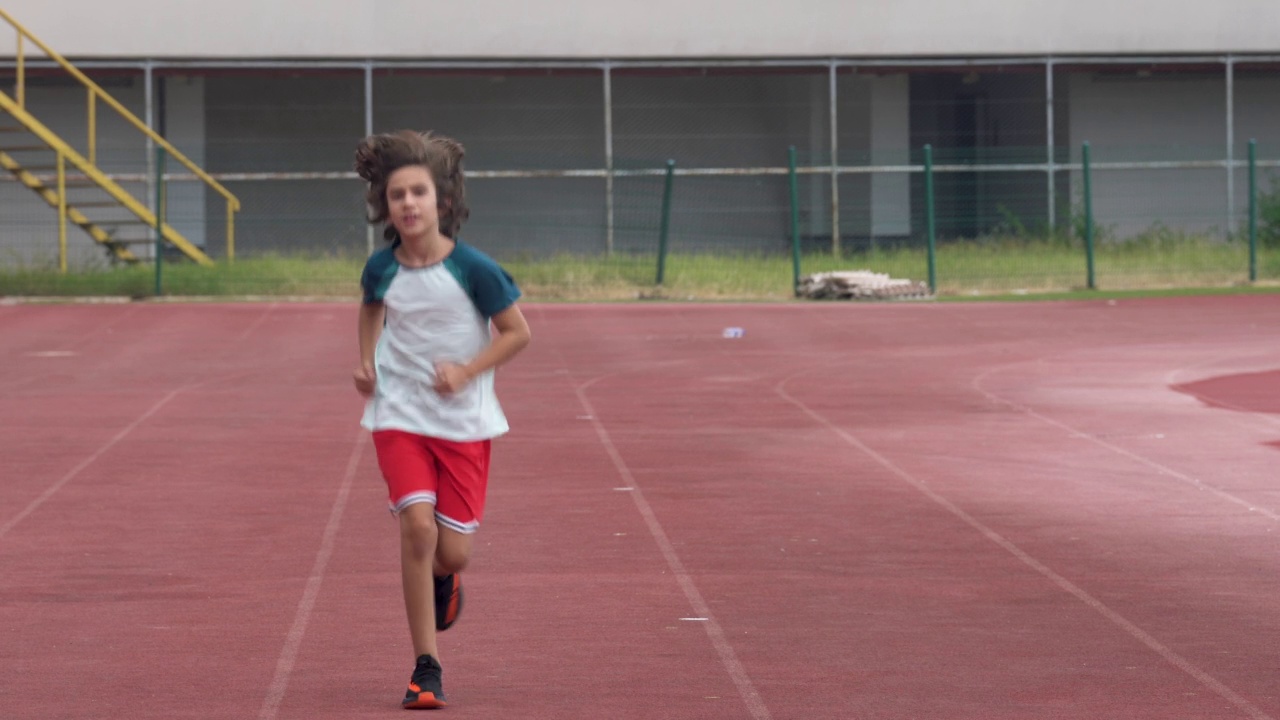 4K视频的男孩在体育场慢跑视频素材