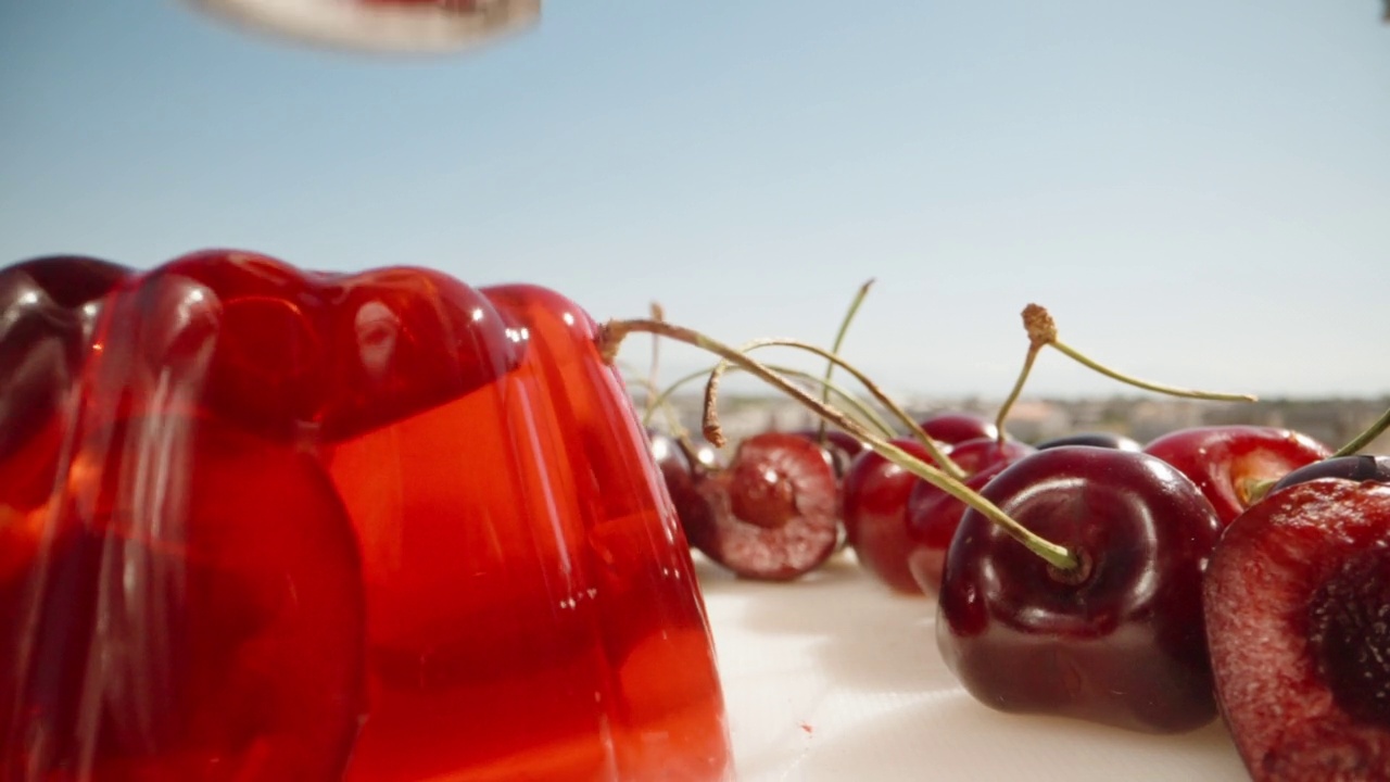 红色的樱桃果冻，我用勺子轻敲果冻，它在晃动，特写。视频素材