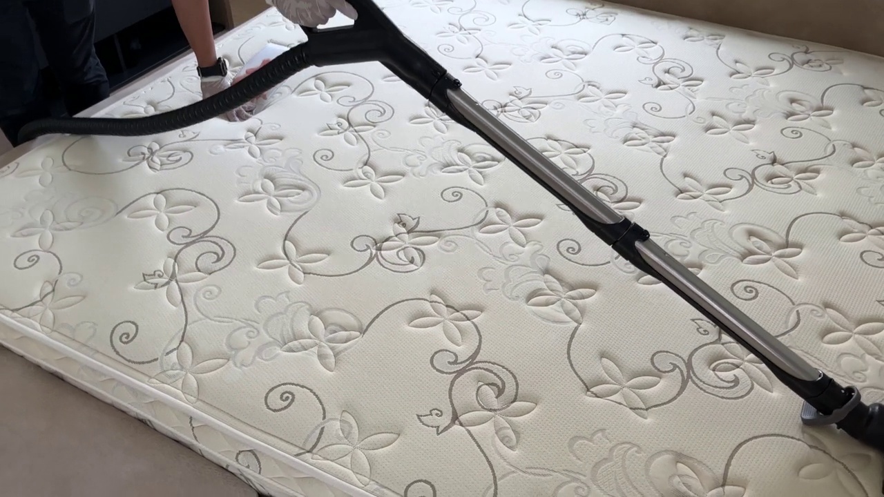 泰国巴吞他尼—2022年9月27日:NCS(自然清洁系统)的专业人员正在使用工业真空吸尘器清洁和清除卧室床垫上的尘螨。(24 fps，含音频)视频素材
