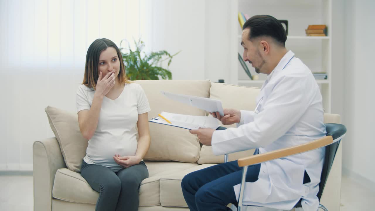 一个孕妇和一个医生看着摄像机的4k慢动作视频。视频下载