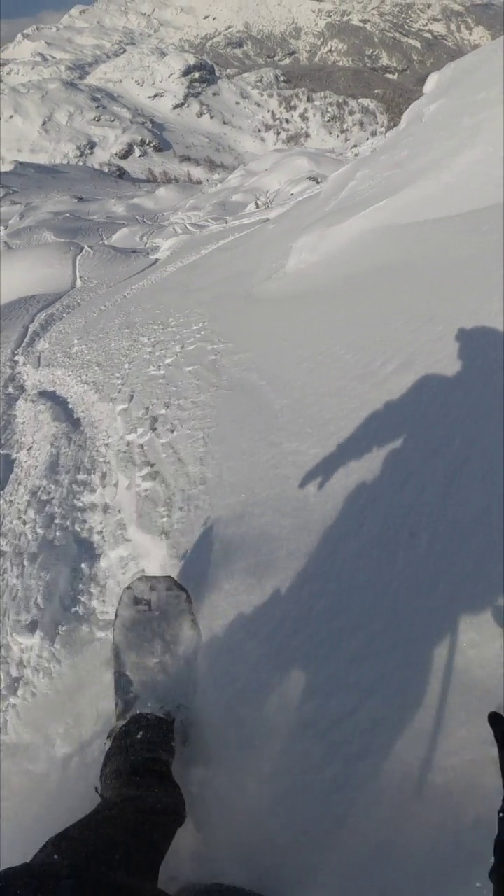 垂直视频POV的一个自由式滑雪板运动员骑通过积雪覆盖的雪视频素材