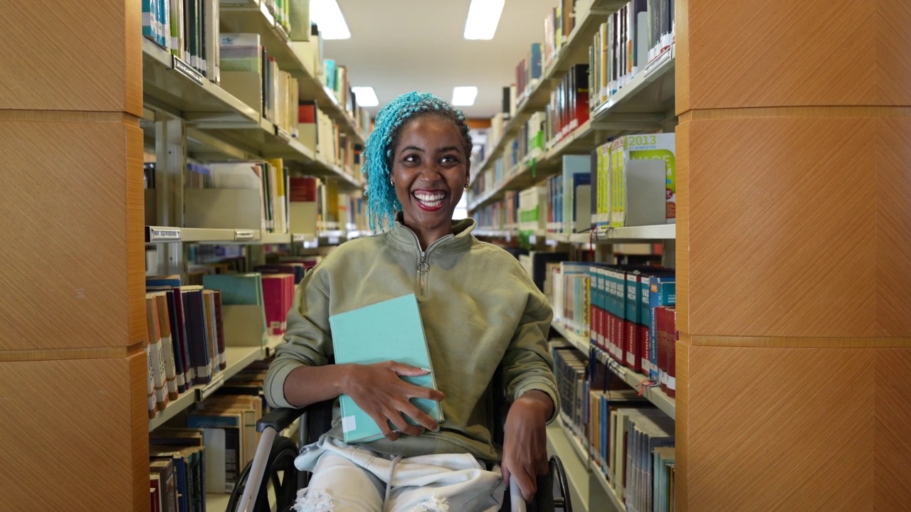 坐轮椅的学生拿着一本书视频素材
