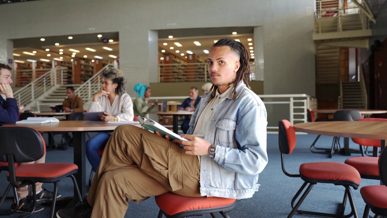 在图书馆读书的学生，腿上放着一本书视频素材