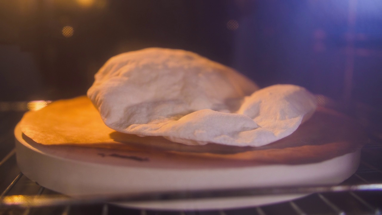 传统的皮塔饼在砖石烤炉上烤制，时间间隔拍摄视频素材