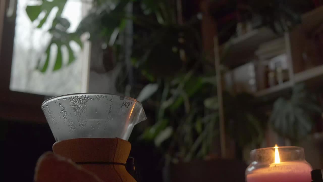 一壶热气腾腾的咖啡靠近蜡烛和植物的舒适景色，黑暗的学术界视频下载