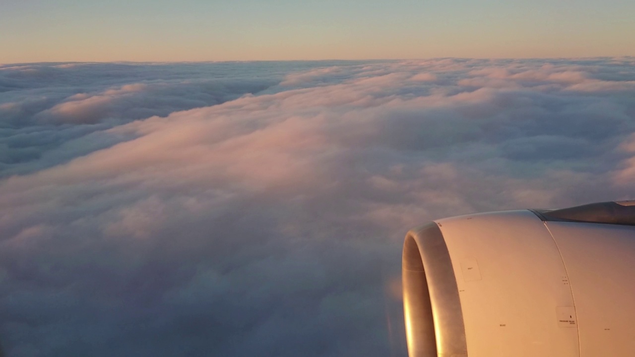 在A330喷气式飞机上从云层上方俯瞰的鸟瞰图。其中一个大引擎清晰可见视频下载