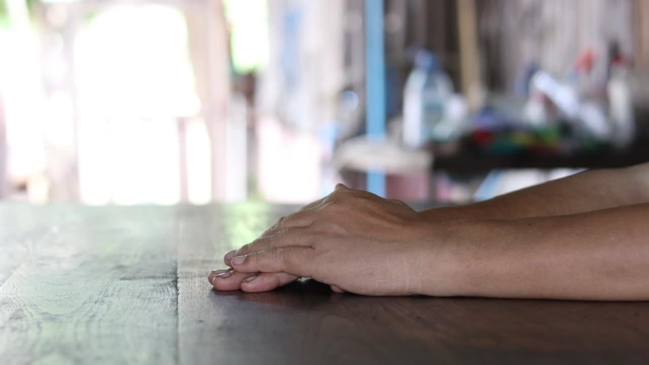 两名泰国老年妇女手牵手互相安慰的特写照片。视频素材