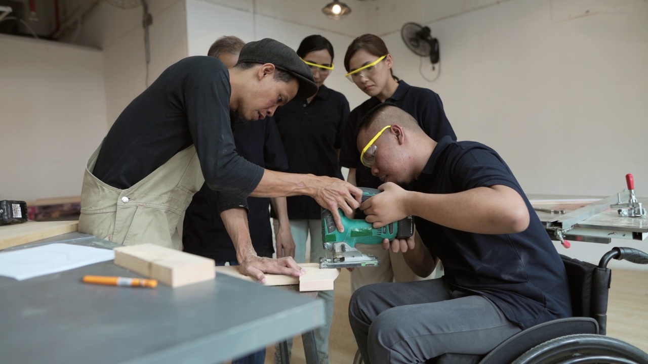 成人学习-坐在轮椅上的亚洲男子在工作坊中学习木制制作的新技能视频下载