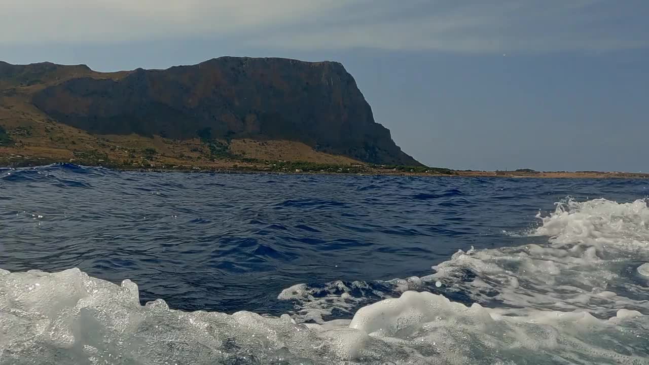 西西里岛的Riserva dello Zingaro自然保护区，从移动的船只上看到海景和悬崖景观。平移水面景观视频素材