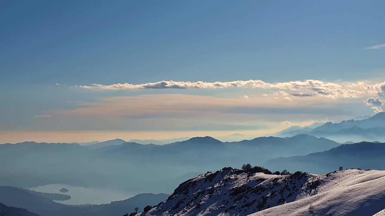 冬季，空中拍摄白雪皑皑的阿尔卑斯山和奥尔塔湖。意大利视频素材