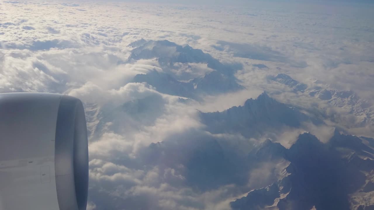 从A330喷气式飞机上俯瞰瑞士阿尔卑斯山。其中一个大引擎清晰可见视频素材