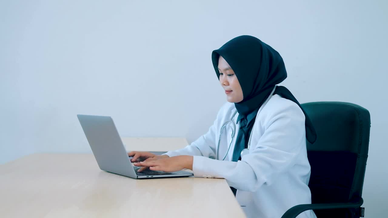 亚洲女医生专注于她的办公室工作的视频。视频素材
