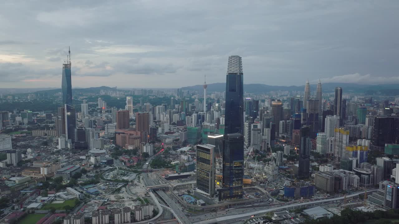 电影无人机镜头的城市与多云的天空周围的摩天大楼在日落。视频下载