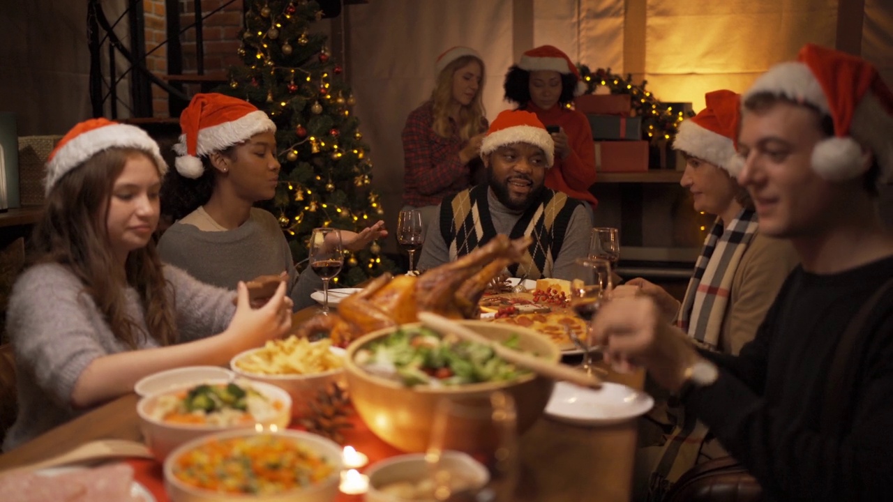 一个多民族的群体。画像的白人和非裔美国黑人家庭在聚会上有一个庆祝晚宴，在圣诞夜快乐，香槟在圣诞节假期在家里。人们的生活方式视频下载
