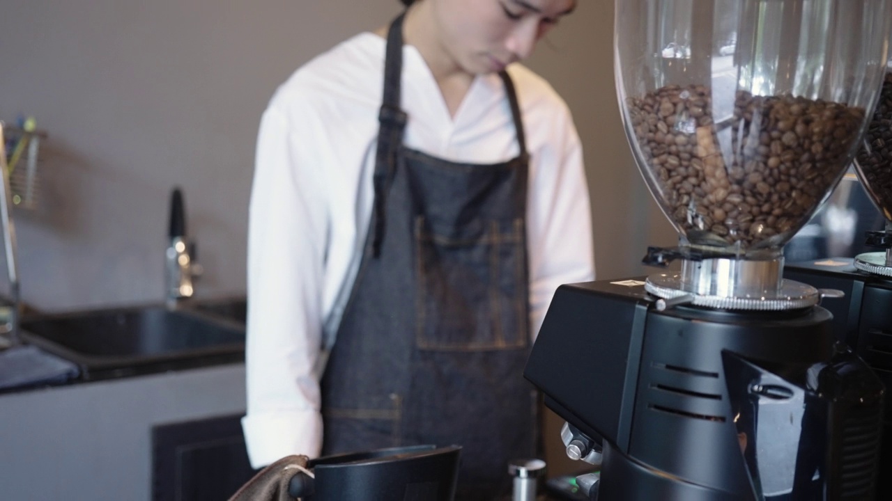 咖啡师的手在制作咖啡的过程中压实咖啡粉与机器在咖啡馆视频下载