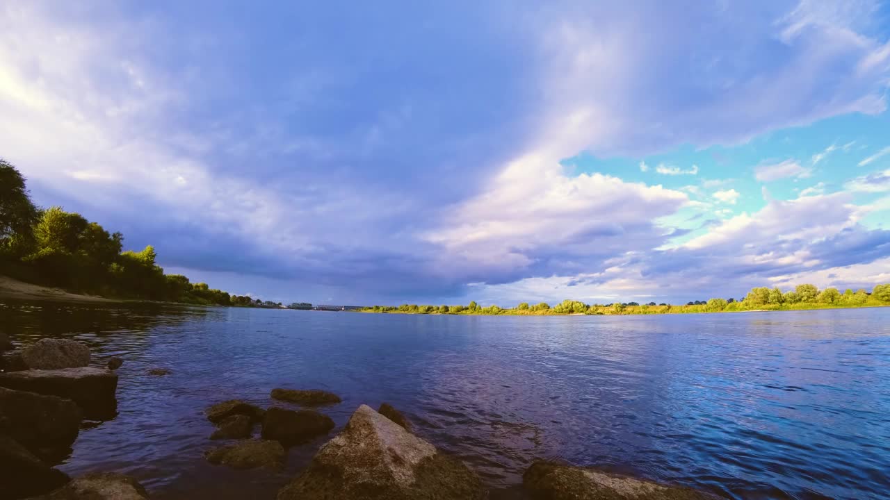 波兰维斯瓦河上日落的时间延迟，天空中有很多云，橙皮色调，相机镜头前有几滴雨视频素材