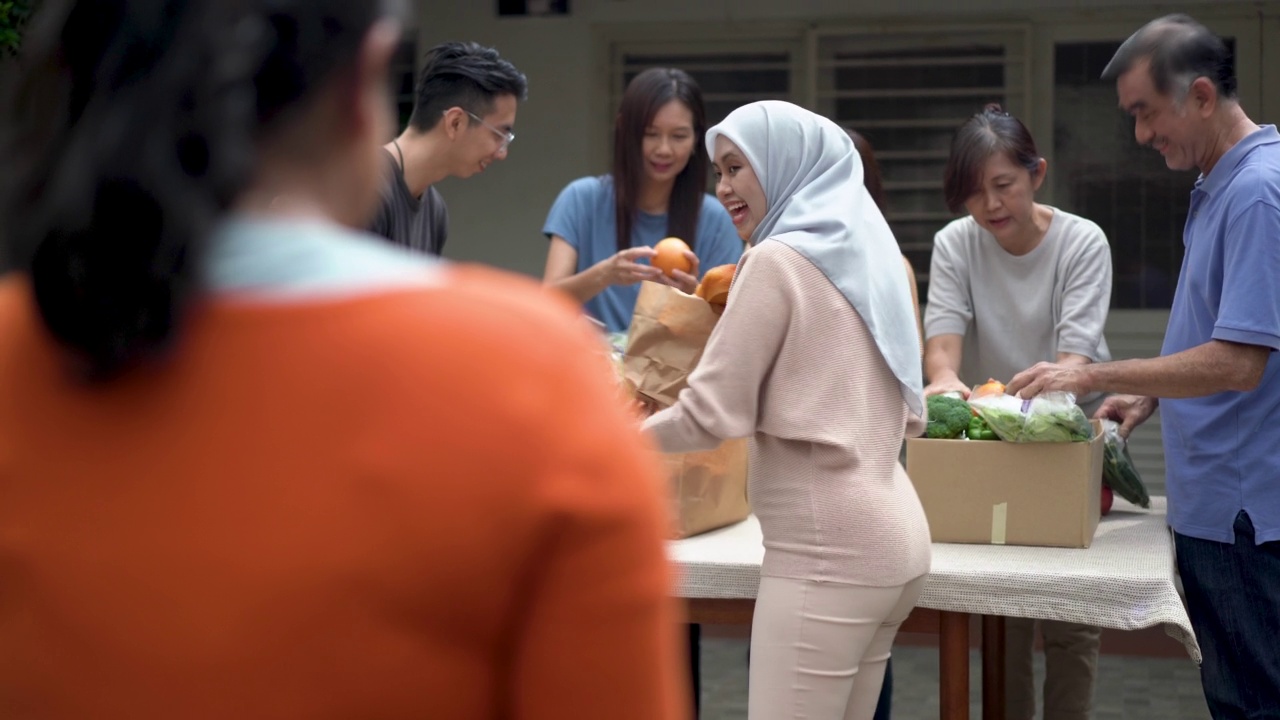 女性志愿者在食物银行为有需要的人提供免费食物视频素材