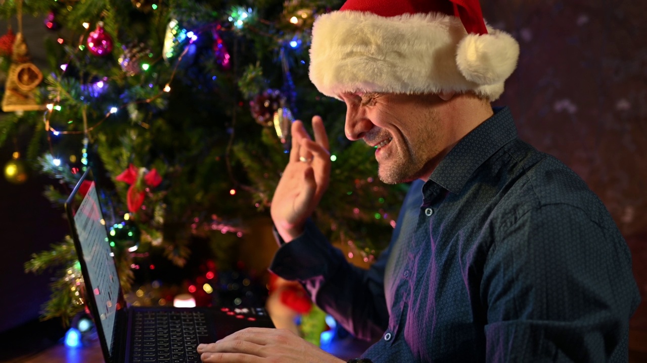 快乐的男人用笔记本电脑给朋友打电话过圣诞节。视频下载