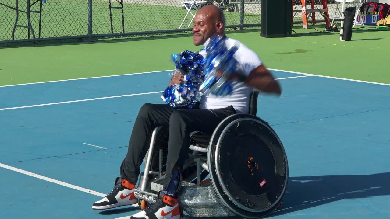 在加利福尼亚州帕萨迪纳适应性体育节期间，残疾的非裔美国人啦啦队长坐在轮椅上跳着乒乓球视频下载
