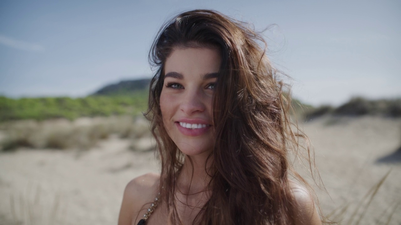 有风的海滩上度假的年轻女子视频下载