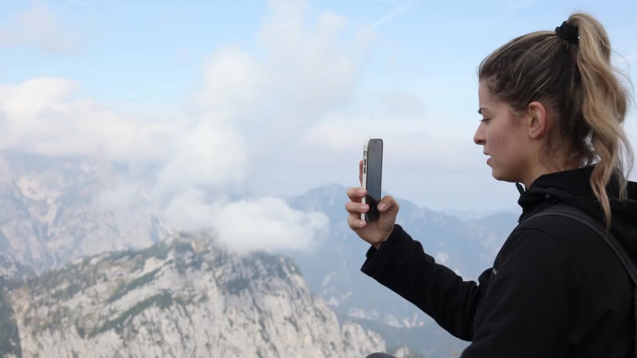 登山女子在山顶用手机拍照视频素材