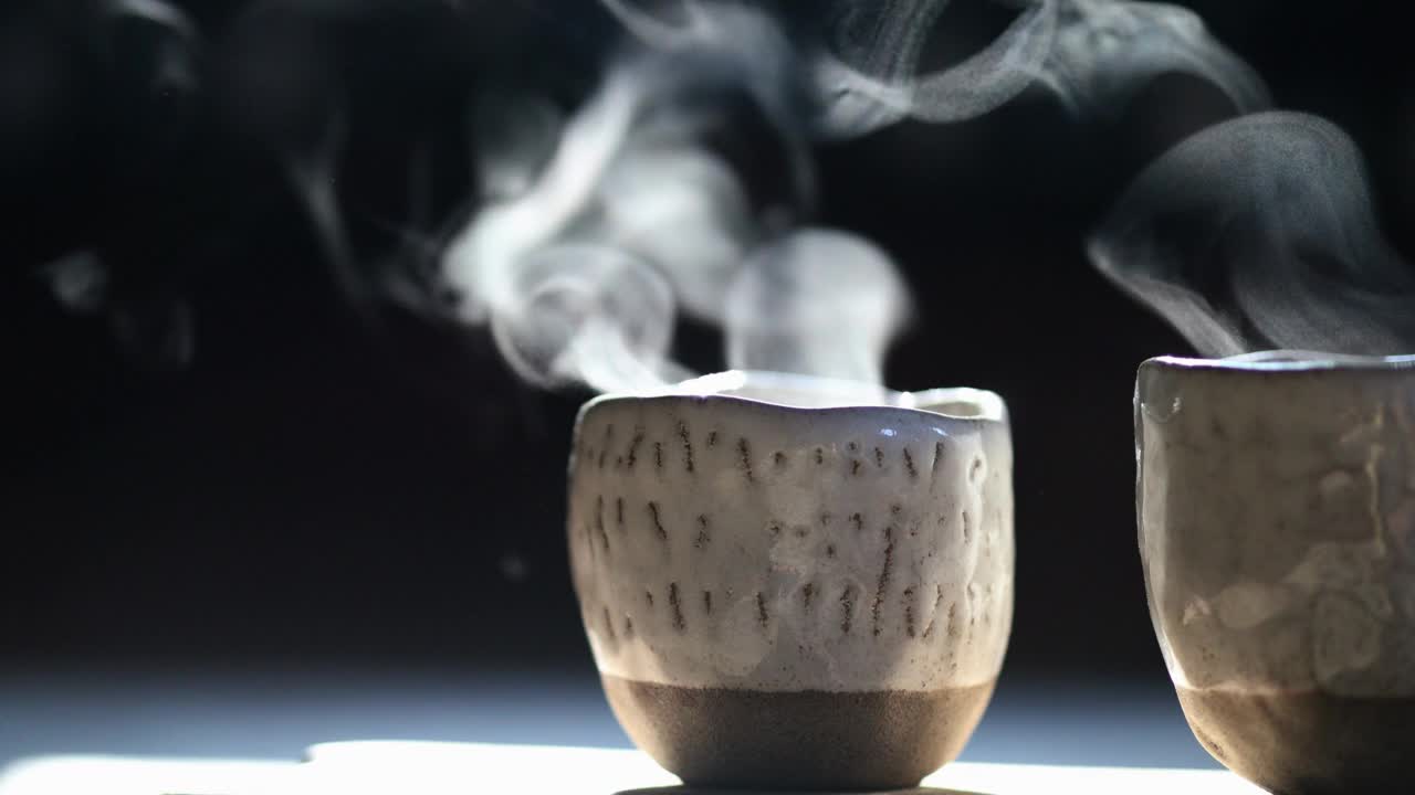 手工艺术咖啡杯蒸在晨光在黑暗的背景视频下载