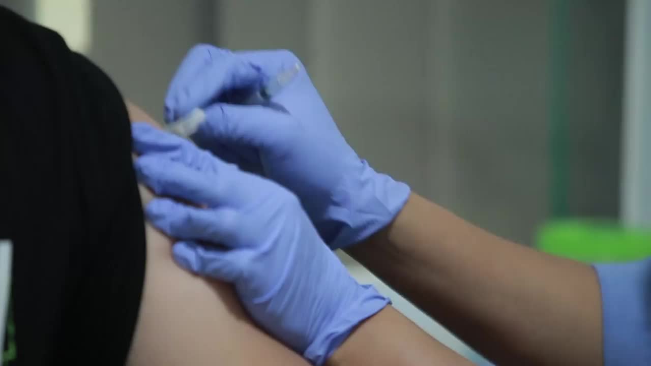 在病人的肩膀上注射疫苗的医生特写、手臂上注射流感疫苗、新冠病毒、准备人体临床试验疫苗注射的新冠疫苗疾病。视频下载