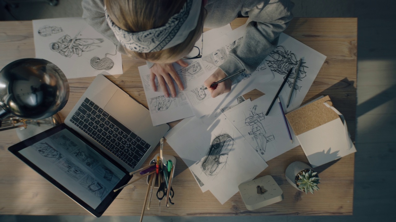 年轻的女艺术家在漫画俯视图的故事板上画铅笔素描作品视频下载
