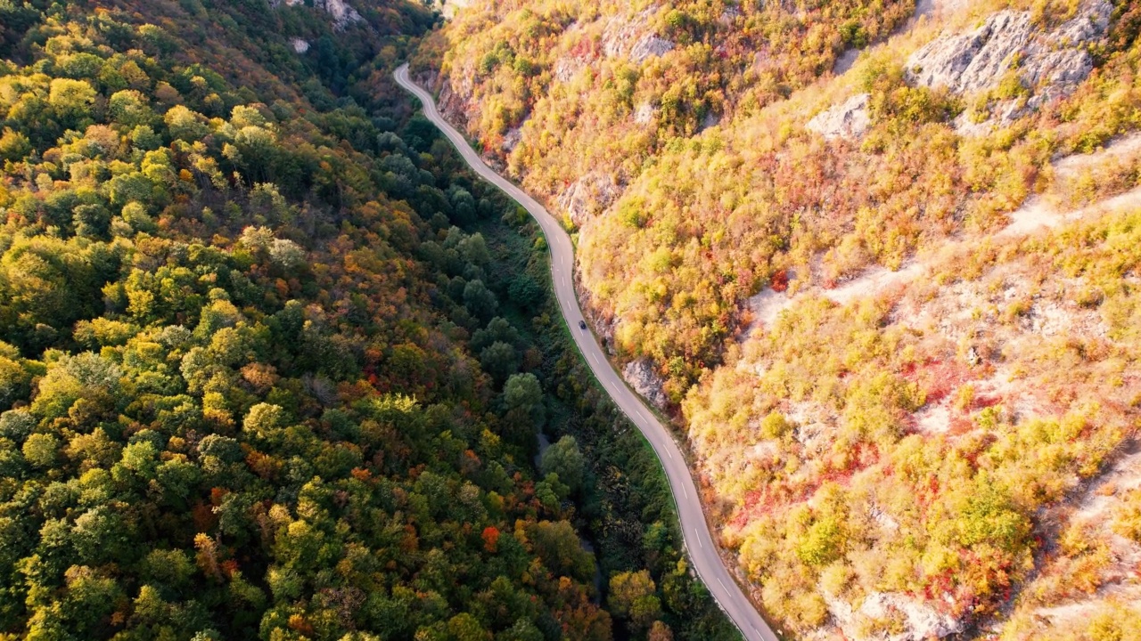 一条穿过峡谷的高速公路，峡谷上画满了秋色视频素材