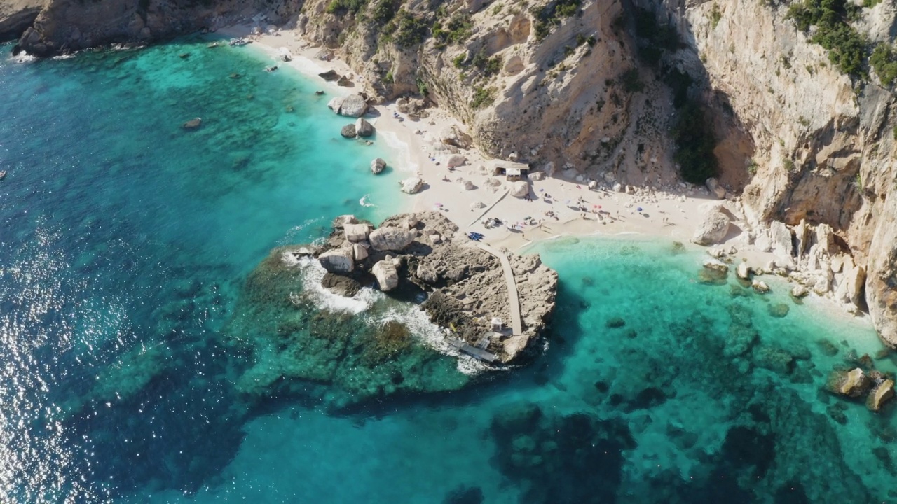 俯瞰绿松石海水和石墩的海滩。意大利撒丁岛，无人机拍摄。夏天海景视频下载