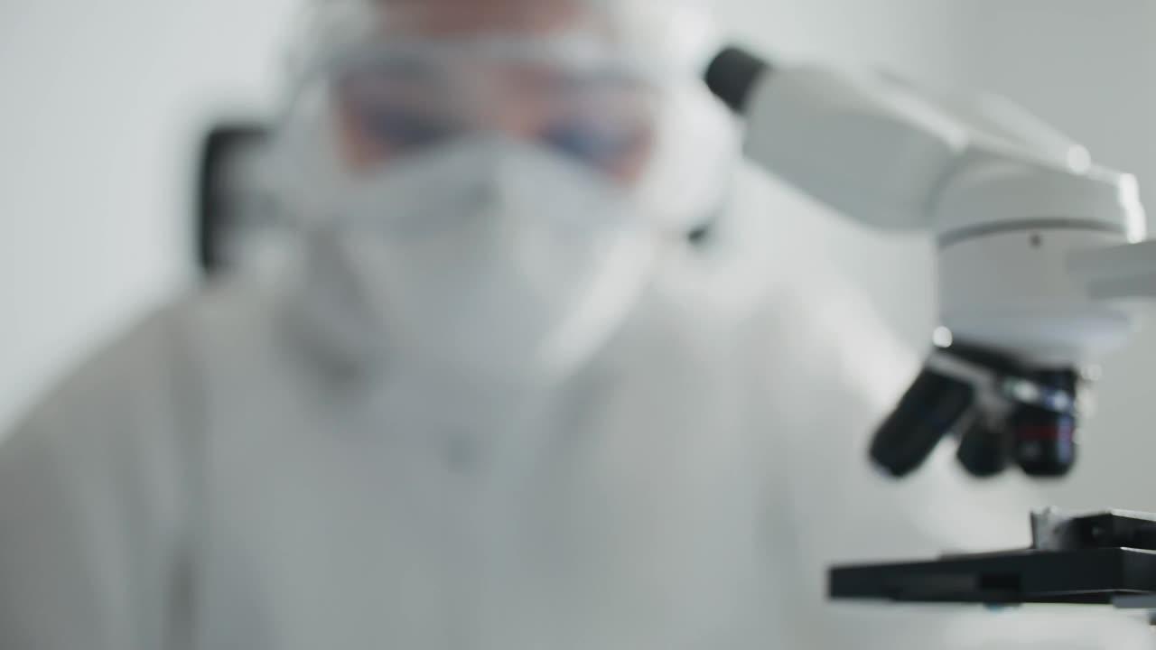 穿着无菌工作服的工程师用手套拿着电脑微芯片检查视频素材