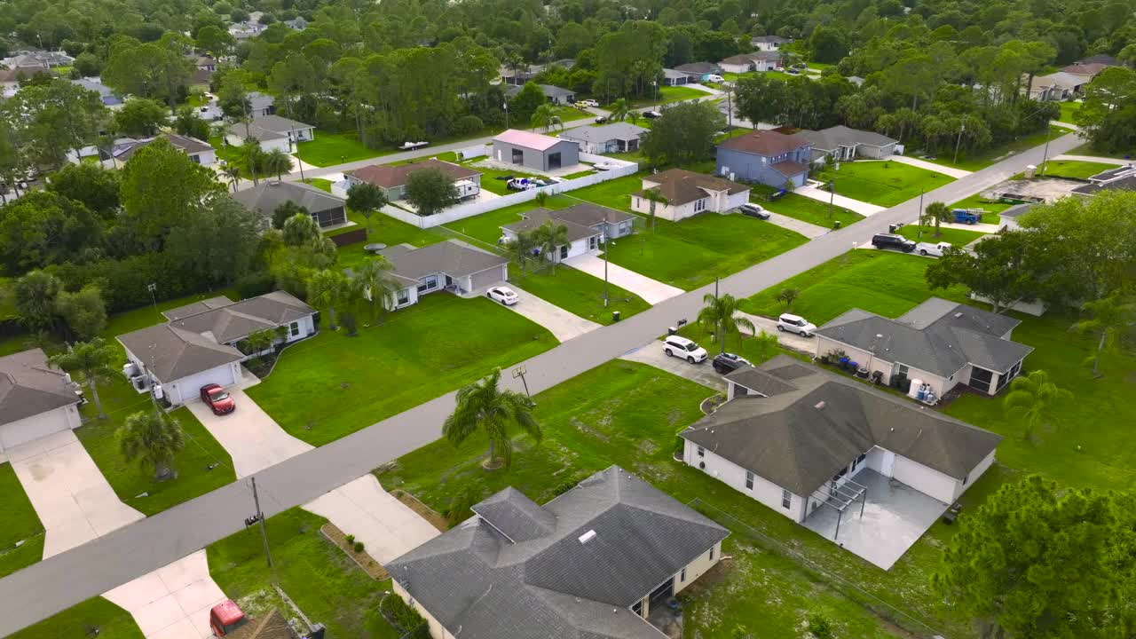 鸟瞰美国小镇郊区景观，私人住宅在绿色棕榈树之间，佛罗里达安静的居民区视频素材