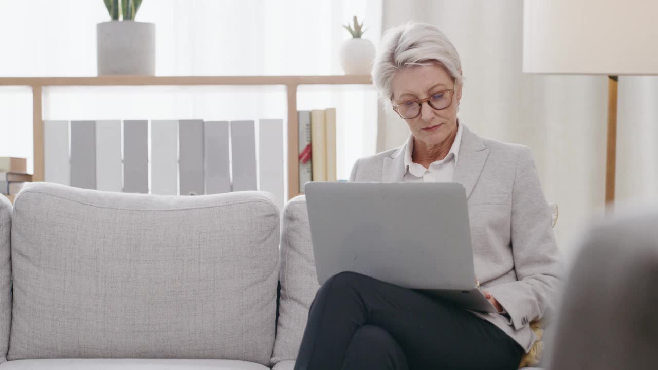 商务女性、经理或员工在笔记本电脑上打字，独自坐在沙发上思考，看上去若有所思。女性在回复邮件时做决定视频素材