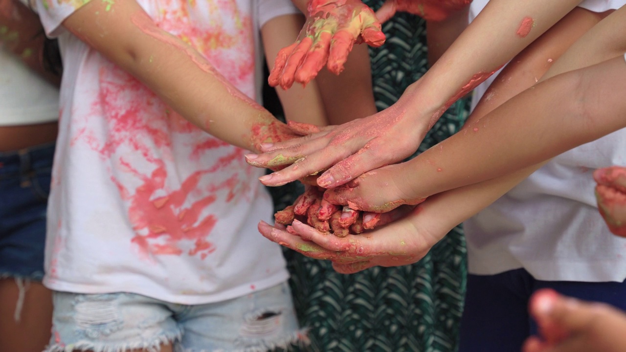 用女生的颜色弄乱的手正在与学习艺术的孩子们手拉手。视频下载