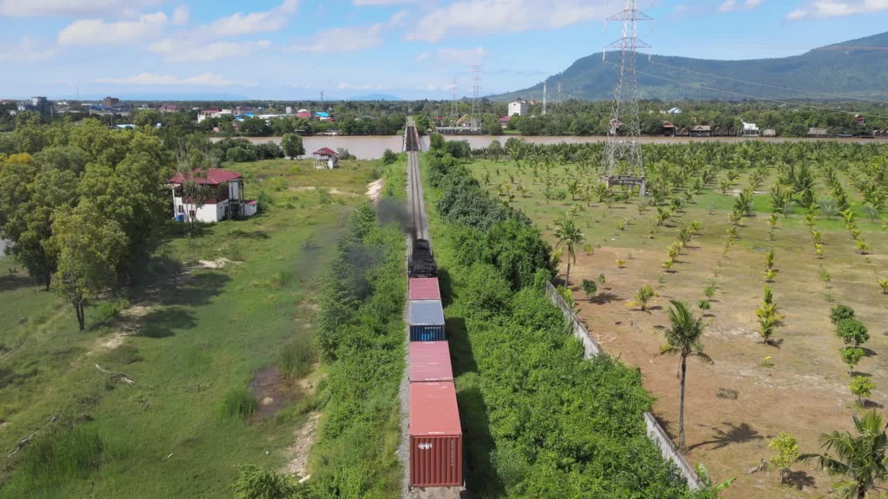 无人机拍摄的货运列车正准备穿过河上的老桥视频素材